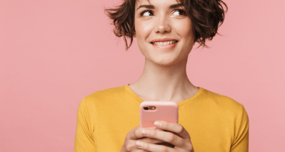 Femme souriant avec un téléphone dans la main