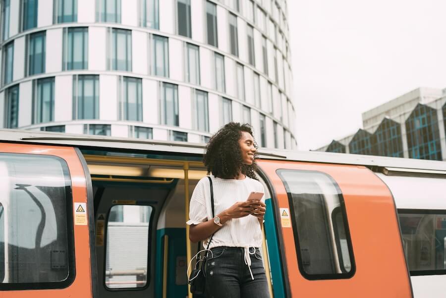 Femme sortant du métro avec son téléphone