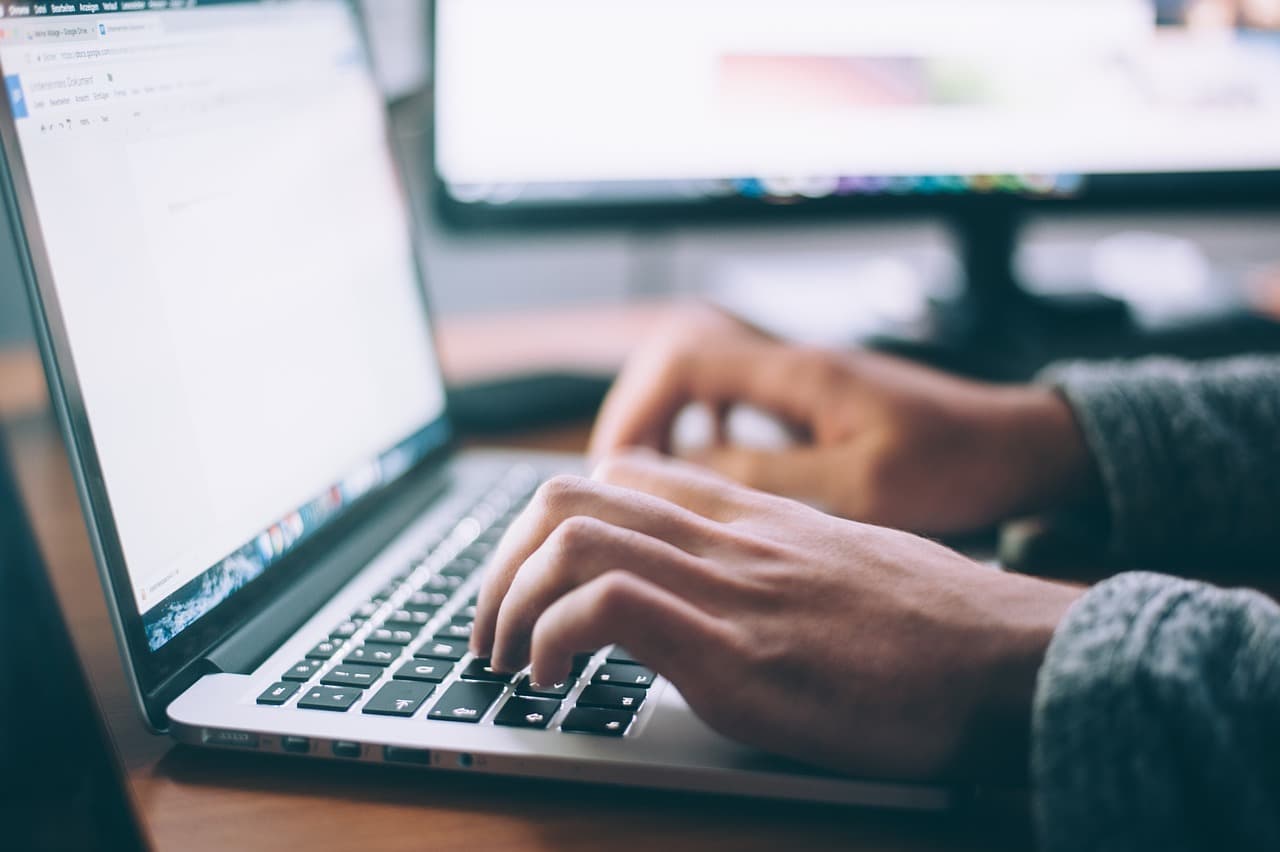 Un homme tapant sur le clavier de son pc portable