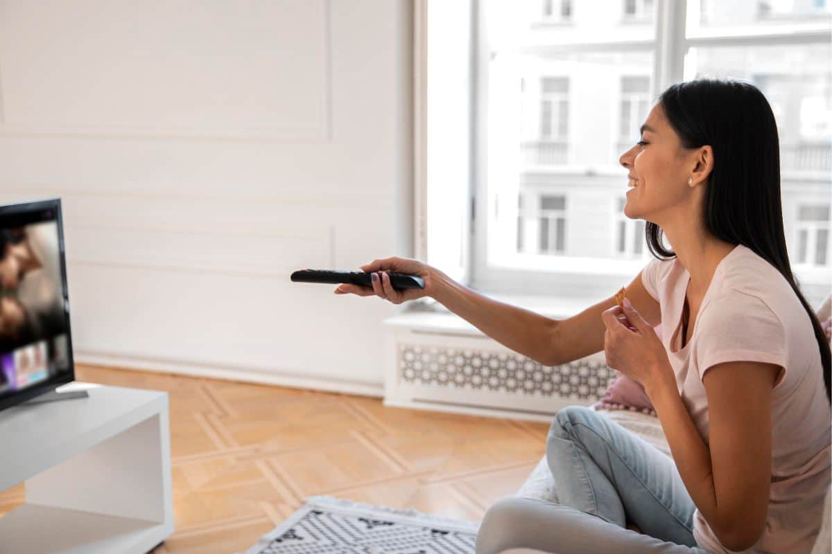 Femme qui utilise sa box SFR pour regarder la télé