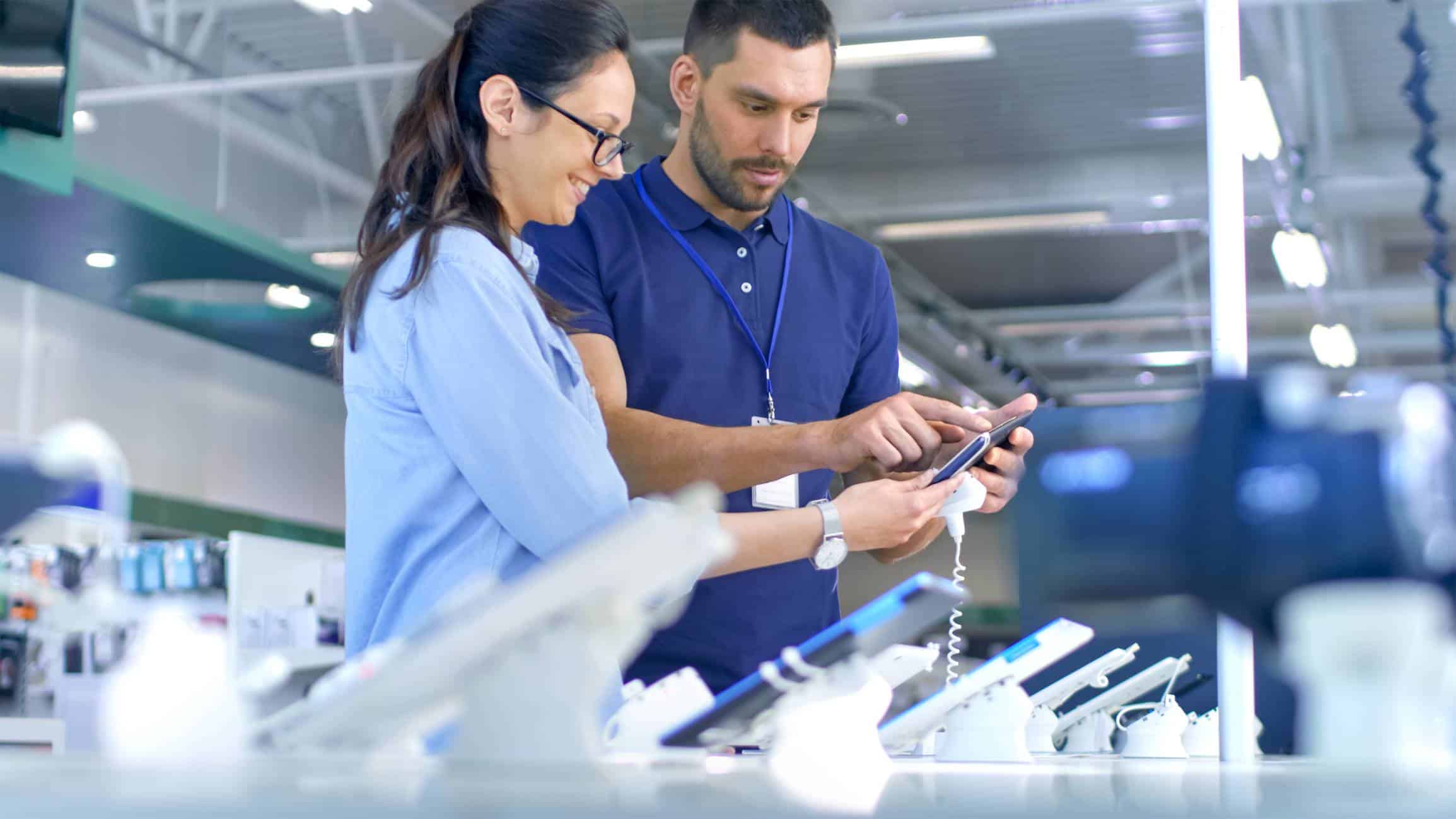 Deux personens regardant un smartphone en vente dans un magasin
