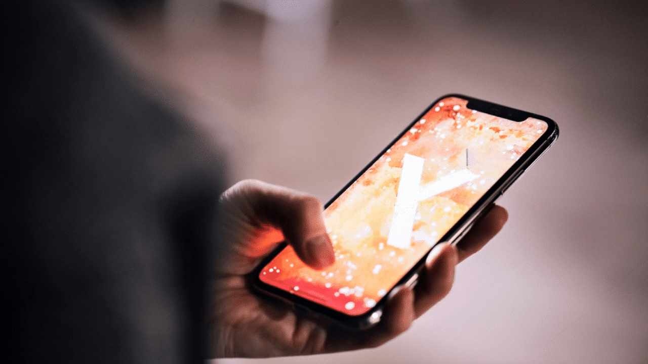 Un iPhone 11 tenu en main