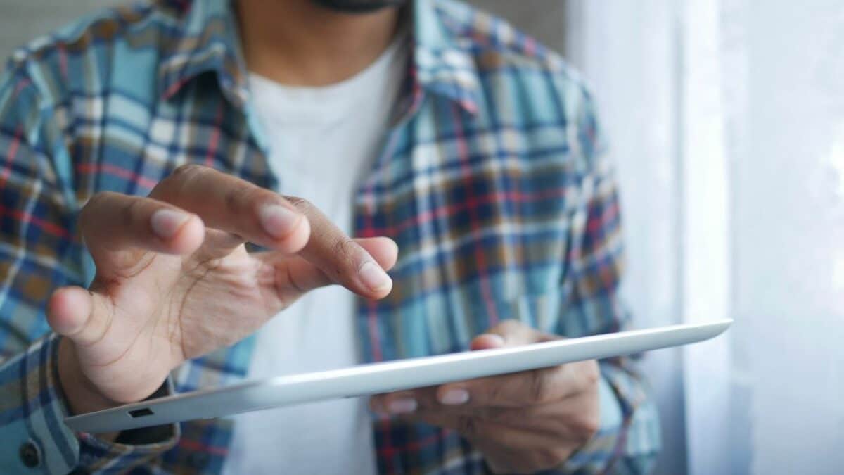 Un homme tapant sur une tablette